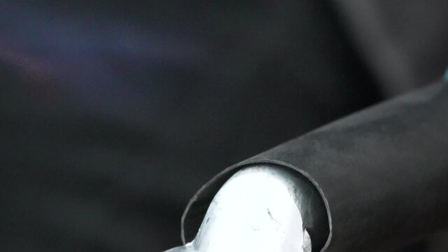 Cable lug heat shrink applied during electrical battery cable assembly process in industrial facility.