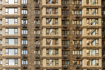 Modern apartment building facade with repeating windows and air conditioning units