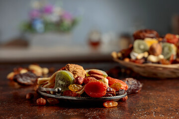 Dried tropical fruits, nuts, and raisins on a kitchen table.