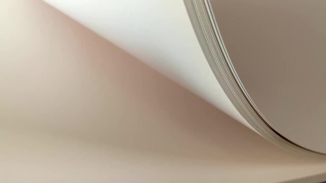 Close-up abstract view of stacked white paper sheets with soft lighting and gentle curves, flipping pages