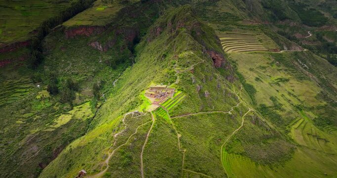 Inca agricultural terraces built on a steep green mountain at Pisac archaeological site, Peru. Aerial backward, copy space