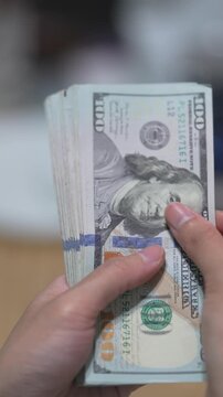 Female hands counting dollar banknotes sitting in room at table. Banking and finance. Business lifestyle. Rich woman hands holding cash money in bank cabinet. Financial job concept. Close up shot