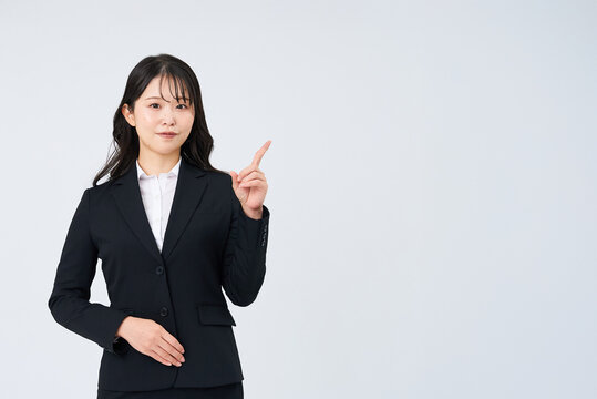 人差し指を立てるポーズをする若いビジネスウーマン