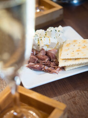 スパークリングワインとホタルイカ・クリームチーズ・クラッカーの盛り合わせ（前ボケ構図）