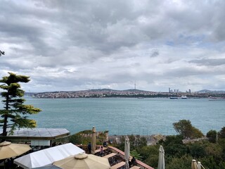 Fototapeta premium Scenic waterfront restaurant with city skyline view on cloudy day