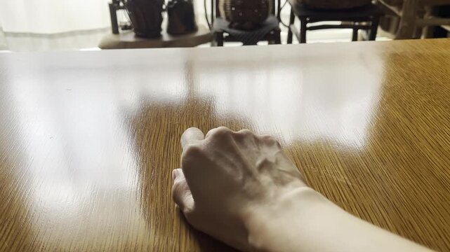 日本の縁起物の起き上がり小法師が起き上がるかチェックしている人
