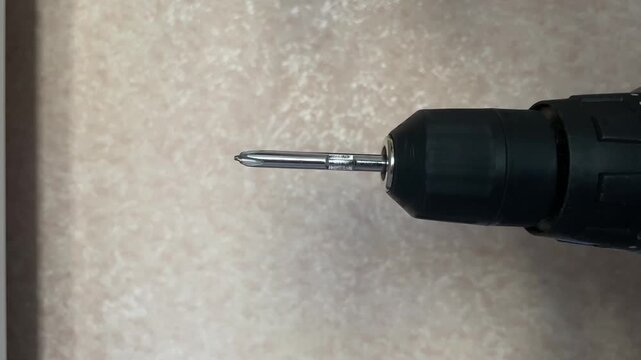 cordless power screwdriver running at speed, metal bit rotating for home repair and DIY work, construction tool detail with motor whine and vibration