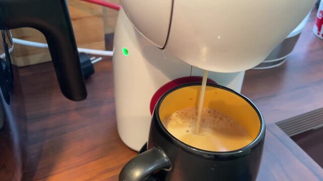 closeup of an espresso machine dispensing steamed milk into a ceramic mug,creamy foam forming on the surface,home cafe concept with pump noise and realistic kitchen ambience sound