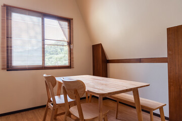 Fototapeta premium Minimalist Japanese Style Interior of a Modern Ryokan Featuring Wooden Dining Furniture and Natural Light for Simple Living