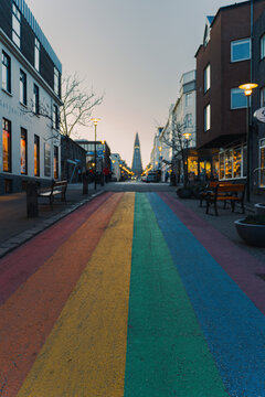 Vertical composition of Reykjavik Rainbow Street leading to Hallgrimskirkja at dawn.
