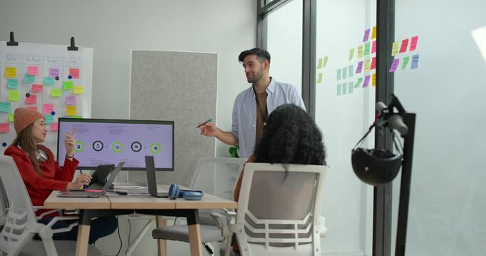 Diverse group of startup team engaging in brainstorming session, using sticky notes on glass wall to organize ideas, plan next steps. Creativity and collaborative spirit of modern entrepreneurial team