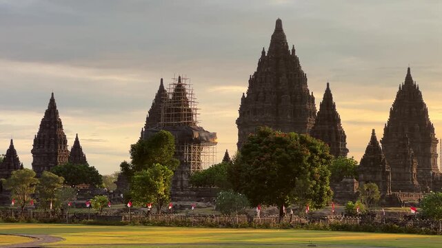 View of the ancient Prambanan Temple at sunset, a Hindu temple complex in Yogyakarta,Indonesia. The temple rises above the green foliage under a multicolored sky, on the southern slope of Mount Merapi