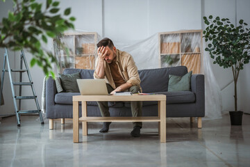 Fototapeta premium Man experiencing renovation stress and financial problems