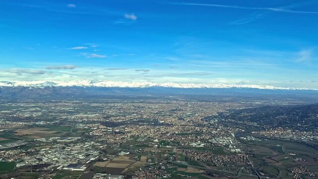 An aerial view of Italian Turin city in the Po Valley, captured from an airplane cockpit approaching to the airport (TRN), with a view of the snowed Alps Mountains