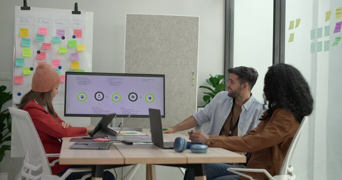 Diverse group of startup team engaging in brainstorming session, using sticky notes on glass wall to organize ideas, plan next steps. Creativity and collaborative spirit of modern entrepreneurial team