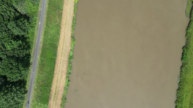 Top-down aerial view of a cyclist riding on a path along the Morava River, summer outdoor activity, drone shot