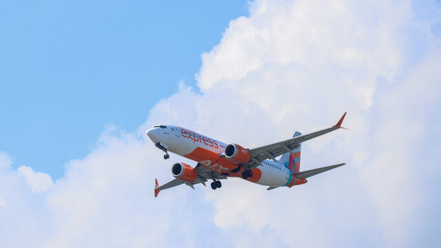 Air India Express Boeing 737 aircraft descending through soft white clouds against a pale blue sky on March 1, 2026 in Bangkok, Thailand