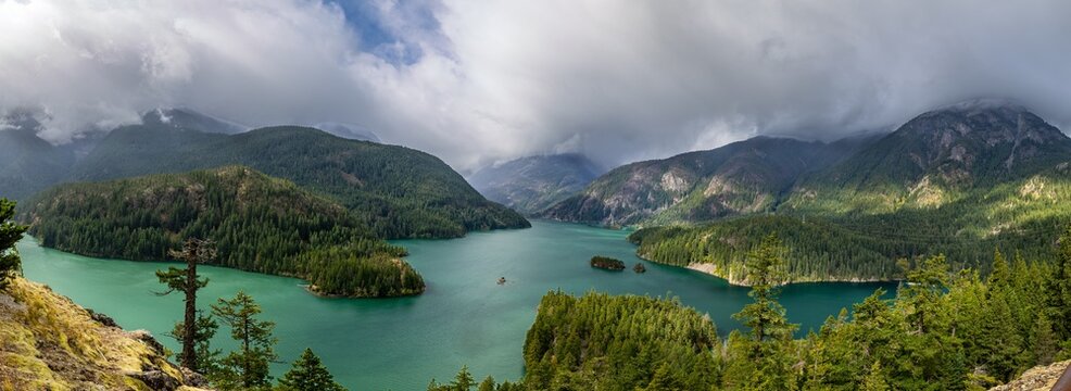 North Cascades' Diablo Lake: Emerald waters, dramatic cloudy mountains.