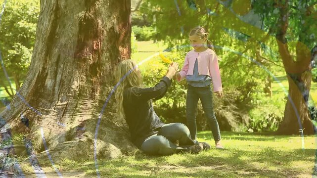 Animation of caucasian mother and daughter in park over shapes