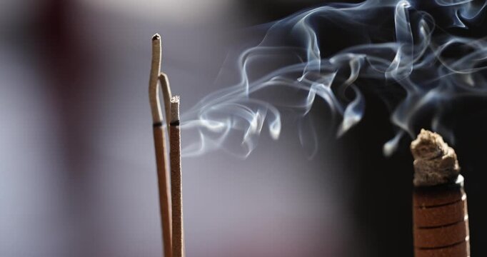 Close-ups and shallow depth-of-field shots capture the moment when incense is burning, and smoke swirls in the temple, showcasing a solemn and tranquil cultural image.