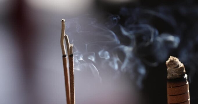 Close-ups and shallow depth-of-field shots capture the moment when incense is burning, and smoke swirls in the temple, showcasing a solemn and tranquil cultural image.