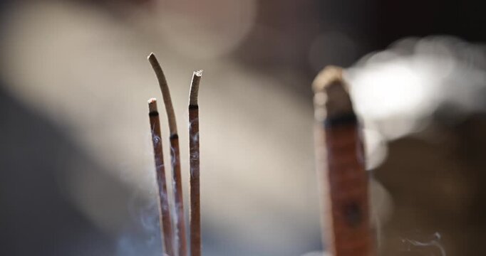 Close-ups and shallow depth-of-field shots capture the moment when incense is burning, and smoke swirls in the temple, showcasing a solemn and tranquil cultural image.