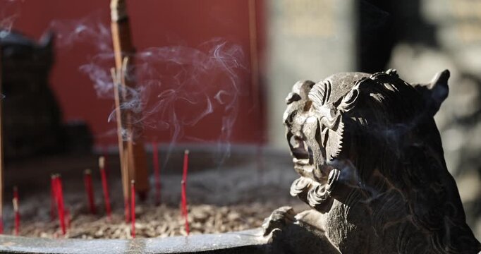 Close-ups and shallow depth-of-field shots capture the moment when incense is burning, and smoke swirls in the temple, showcasing a solemn and tranquil cultural image.