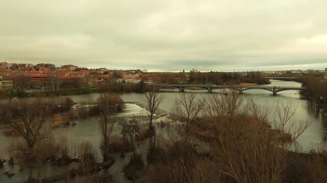 Aerial panorama of Salamanca with the Tormes River at high water level after heavy rainfall. City skyline and river landscape in Spain.