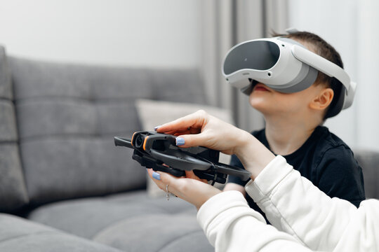 Young caucasian child exploring vr while holding drone robor