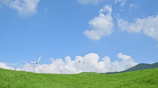 新緑の草原と青空に回る風力発電の風車
「阿蘇外輪山の西端、俵山の中腹に位置する。標高約1,100mの爽やかな新緑の丘に、真っ白な風車が並ぶ光景は圧巻。エコ、エネルギー、観光、日本の夏といった幅広いテーマの背景素材に最適です。」
阿蘇郡西原村(俵山)（ウインドファーム）
Wind turbines spinning against a fresh green field and blue skies