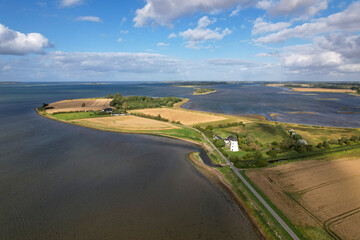 Wide aerial shot of a tranquil coastal region showing the meeting point of farmland and ocean