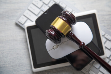 Obraz premium Judge gavel with a phone, tablet, computer keyboard.