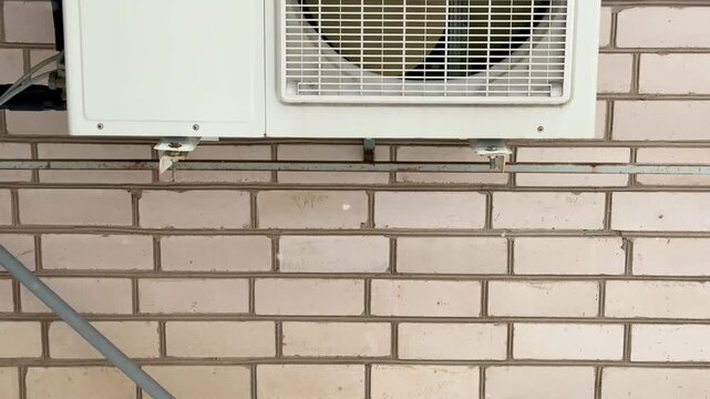 Close-up of an industrial air conditioner fan, radiator grille, rotating blades, gears. Routine inspection and repair.