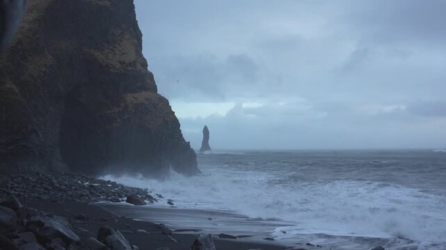 Der schwarze Strand Reynisfjara auf Island bei sehr starken Wellengang und stark bew&ouml;lkten Himmel	