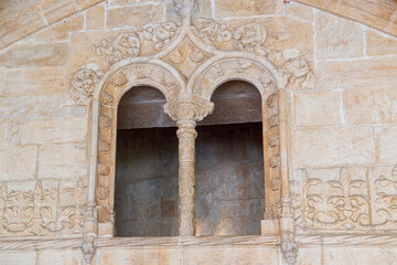 Fototapeta premium Portugal, Lisbon - 05 Aug 2018: An ornamented arched window in the cloister of the Jeronimos Monastery