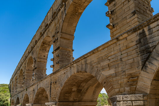 Pont du gard roman aqueduct ancient engineering marvel featuring multiple tiers of stone arches under a clear blue sky
