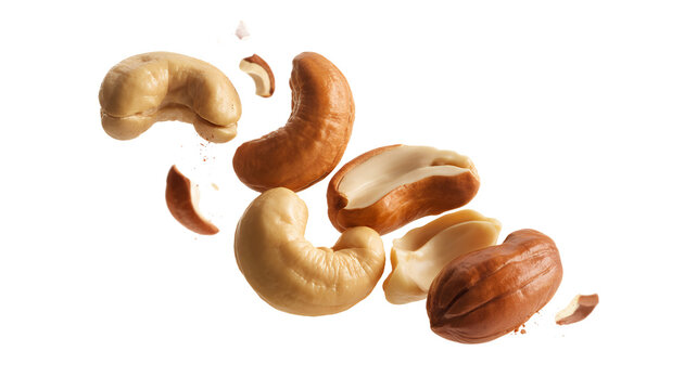 Cashews and cashew pieces flying on white background isolated on a transparent background