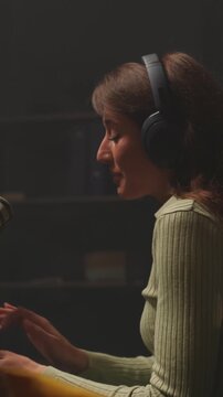 Woman hosting podcast with microphone, Host alternating between interviewer and storyteller in studio setting