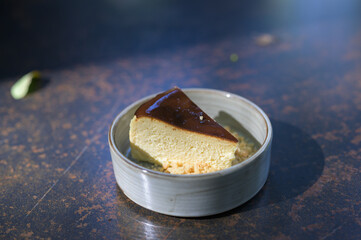 slice of vanilla cheesecake on outdoor iron table. dessert, creamy.