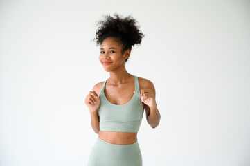 Beautiful young African American girl posing with fitness clothes isolated over white background. Healthy and Fitness concept.