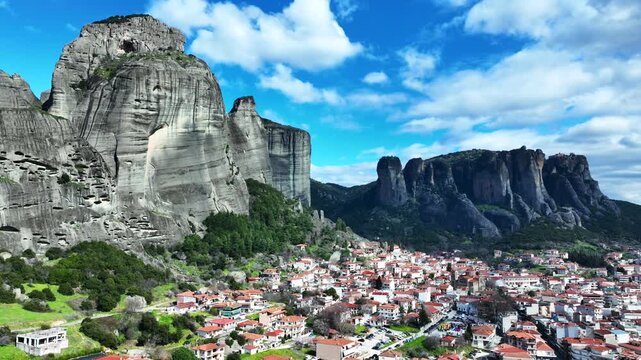 Aerial drone cinematic video of breathtaking view of famous rock pillars of Meteora featuring Orthodox monasteries as seen from village of Kalabaka, Thessaly, Greece