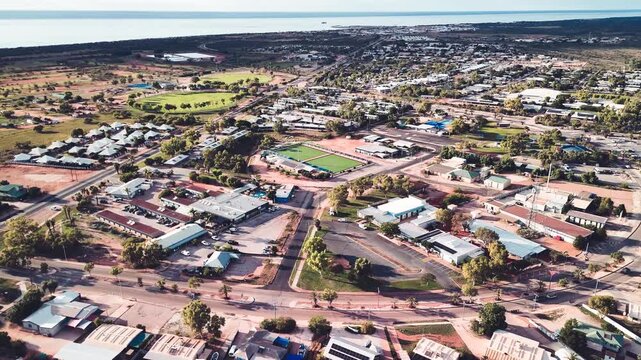 Birds eye perspective showcasing Exmouth neighborhood houses coastal township harbor turquoise ocean backdrop Australia