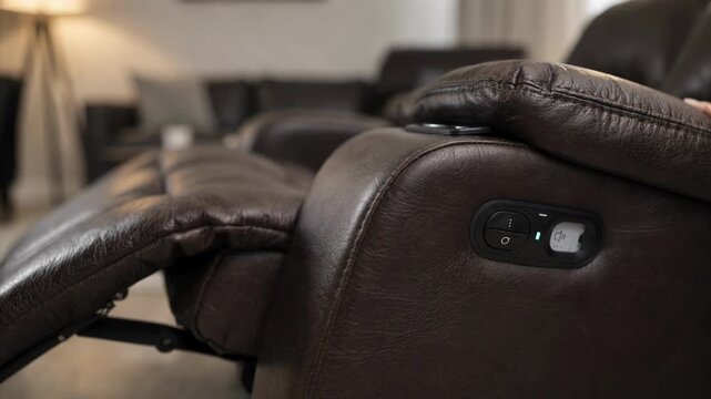 Leather recliner armrest and control panel in sharp detail technician analyzing timeout issue with softly blurred living room backdrop.