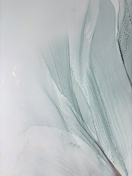 Abstract pale green hand made aquarelle background with beige. Beautiful watercolor artwork made with alcohol ink. Light green smoky fluid art texture resembles green mist, marble, water, ocean, flow.