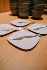Restaurant table setting with empty white plates and napkins