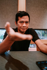 Obraz premium Young man making inviting gesture with outstretched hand