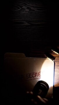 Top Secret Document Folder Illuminated by Flashlight with Bullets on a Dark Wooden Desk, Espionage and Classified Information Concept