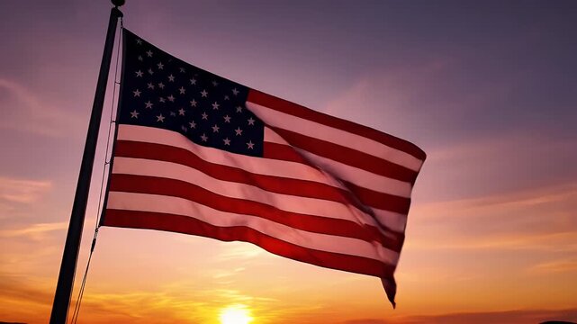 American Flag Waving at Sunset - An American flag waving in the wind against a colorful sunset sky. The flag is backlit by the setting sun, creating a dramatic and patriotic video.
