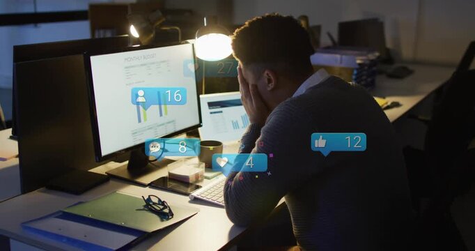 Business analyst at desk studying charts and hunching with alert bubbles rising on screen