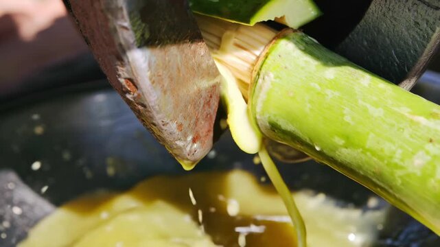 Fresh sweet sugarcane juice dropping metallic crushing machine traditional indian street summer beverage refreshing agriculture organic tropical drink local healthy lifestyle delicious